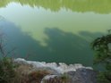 Strmý pohled po skále dolů do zelené vody Víru.